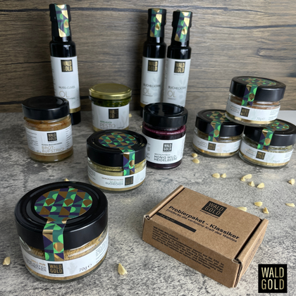 Eine Auswahl an verschiedenen Gläsern und Flaschen mit Lebensmitteln und Gewürzen auf einer Tischoberfläche. Die Produkte sind stilvoll etikettiert und gut angeordnet.