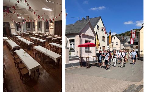 Ein festlich dekorierter Saal mit langen Tischen und Bänken. Auf der anderen Seite gehen Menschen an bunten Häusern vorbei.