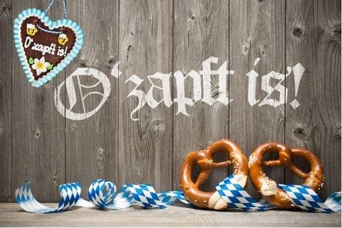 Bunte Wimpel dekorieren einen Garten unter einem klaren Himmel. Im Hintergrund sind grüne Bäume sichtbar.