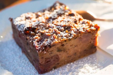 Ein schmackhaftes Stück Kuchen mit einer glänzenden Oberfläche und Puderzucker bestreut. Die Kombination von Aromen und der saftige inneren Textur machen es sehr appetitlich.