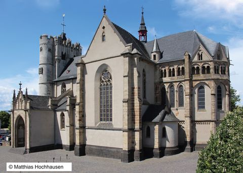 Eine beeindruckende Kirche mit gotischen und romanischen Elementen. Das Gebäude hat mehrere Türme und große Fenster, die Architektur ist vielseitig und historisch.