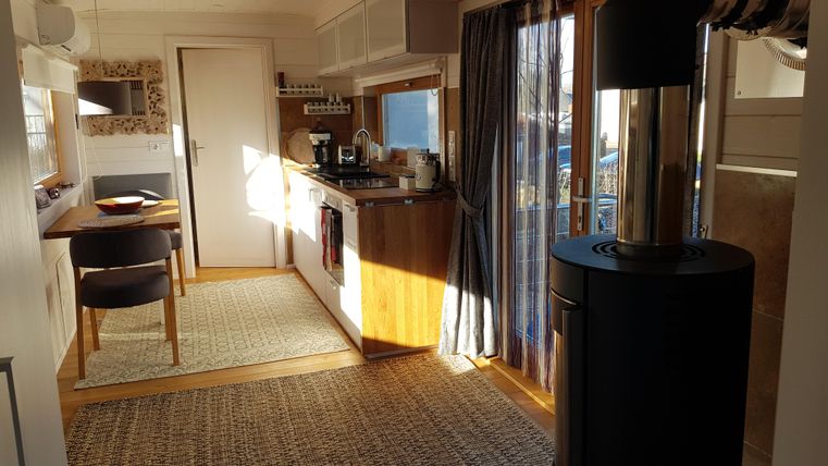 Eine gemütliche Küche mit modernen Geräten und einem Essbereich. Eine Holzheizung sorgt für eine einladende Atmosphäre.