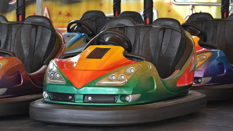 Ein farbenfrohes Autoscooter-Auto steht auf einem Jahrmarkt. Es hat eine glänzende Oberfläche und ist bereit für Spaß und Aktion.