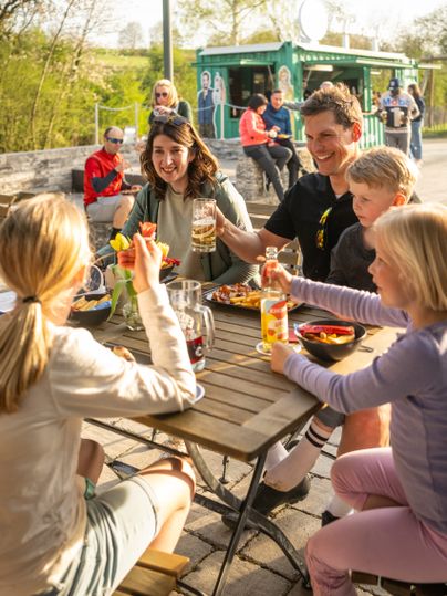Eine Familie beim gemeinsamen Essen im Biergarten im Alten Bahnhof Ochtendung