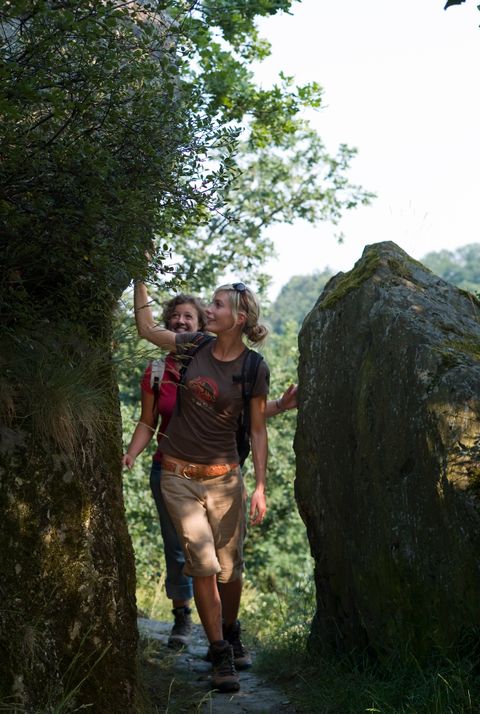 Wanderer gehen durch hohe Felsen am Traumpfad.