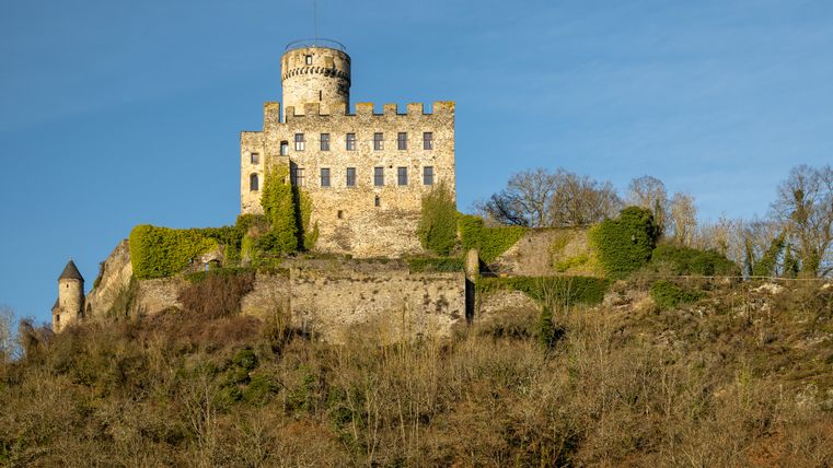 Burg Pyrmont auf einem Hügel mit blauem Himmel im Hintergrund.
