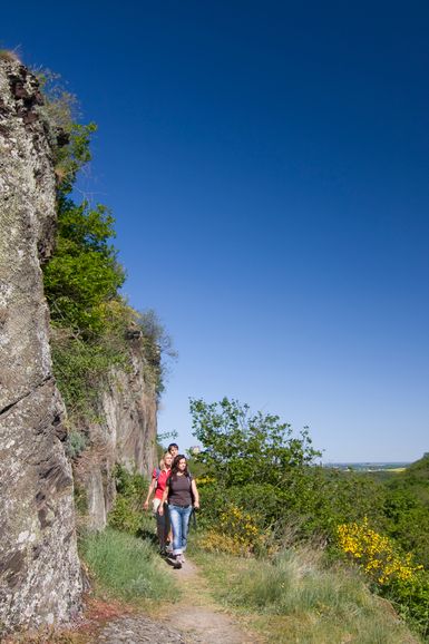 Wanderer laufen am Felsen entlang auf dem Traumpfad Pyrmonter Felsensteig