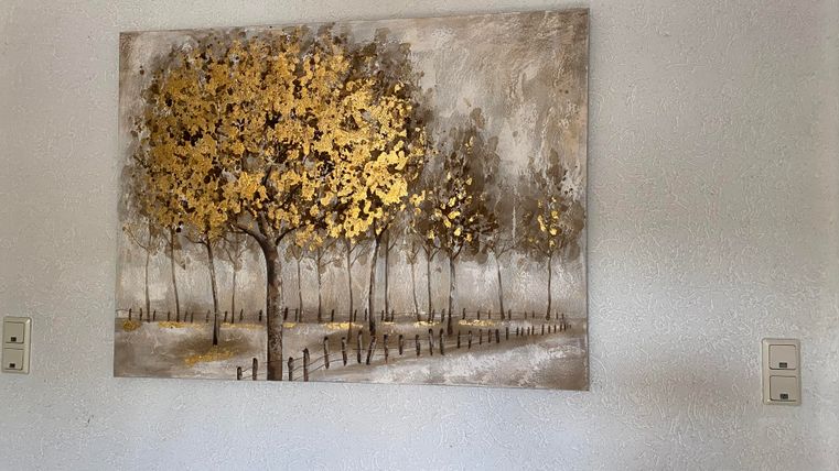 Ein Gemälde mit goldenen Bäumen auf einem grauen Hintergrund. Der Weg führt durch eine Allee von Bäumen, die in sanften Farben dargestellt sind.