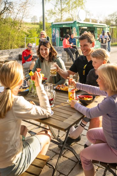 Eine Familie beim gemeinsamen Essen im Biergarten im Alten Bahnhof Ochtendung