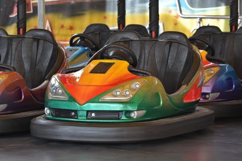 Bumper Cars in verschiedenen Farben stehen bereit in einem Freizeitpark. Die Fahrzeuge haben ein modernes Design und sind bereit für Spaß und Action.