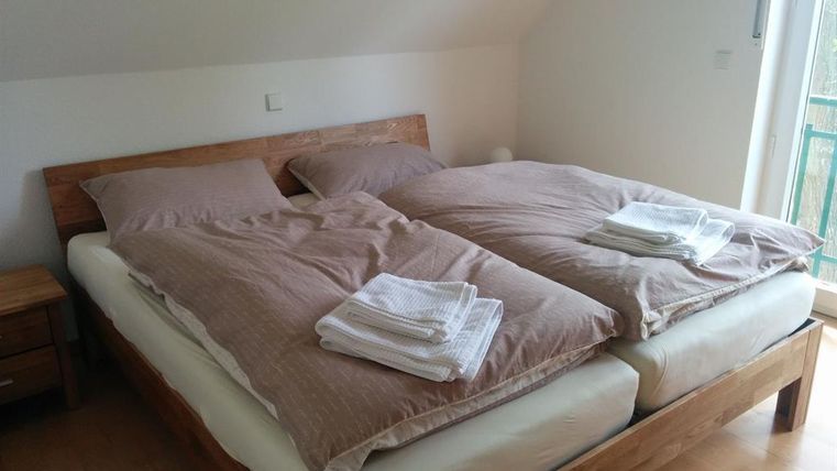 Ein gemütliches Schlafzimmer mit einem Doppelbett. Die Bettwäsche ist ordentlich und frische Handtücher liegen bereit.