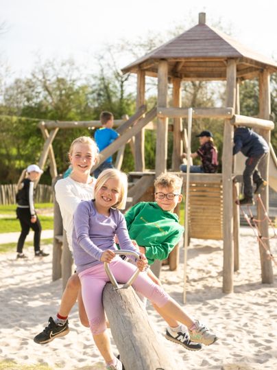 Kinder spielen auf einer Wippe auf dem Spielplatz am Alten Bahnhof in Ochtendung am Maifeld-Radweg